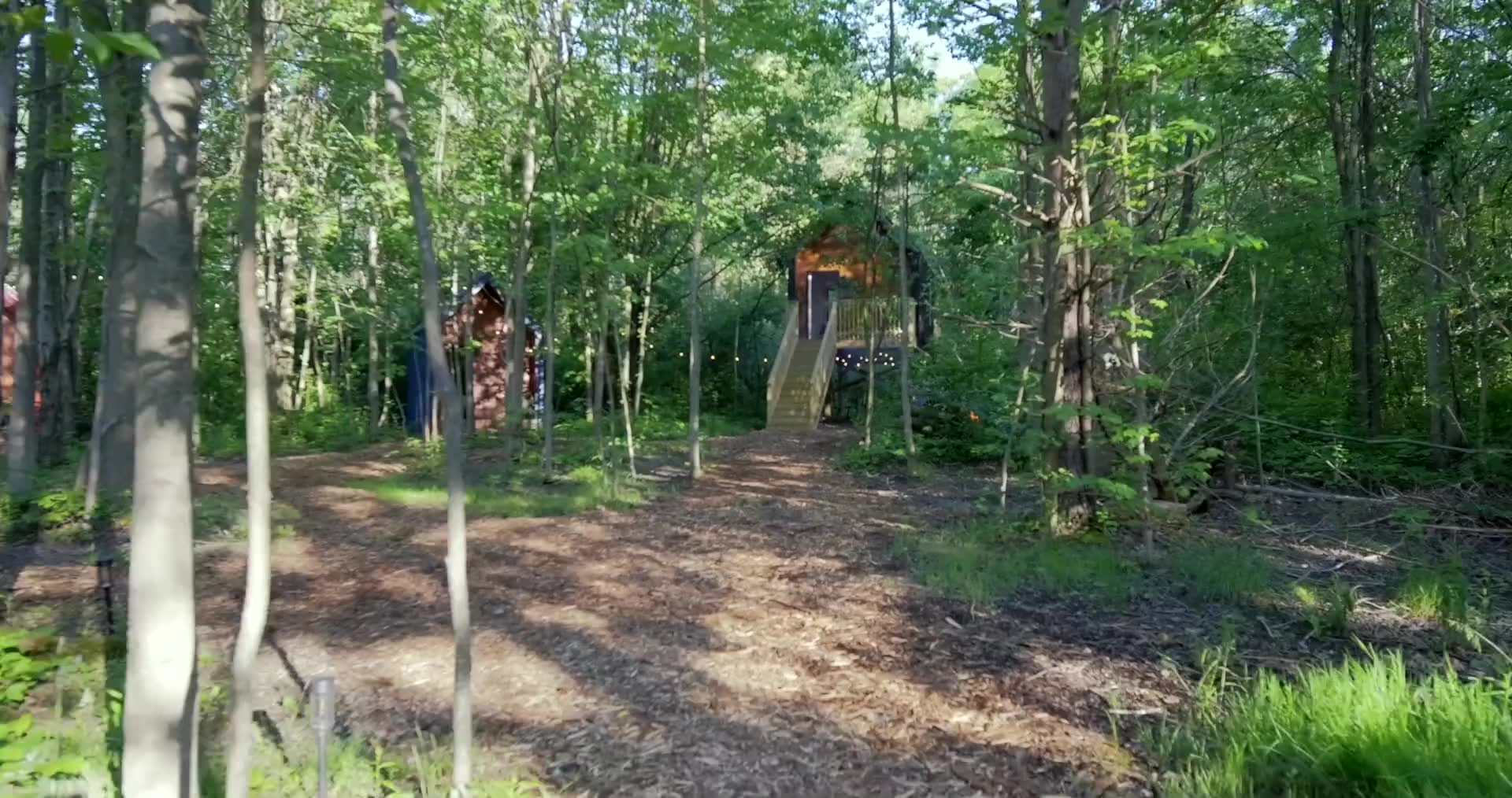 Nordic Pines cabins among the trees, a cabin bedroom, and the fire pit at dusk